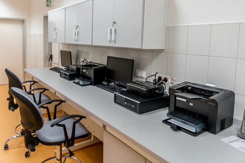 Waar vind ik de camera op de printer en hoe typ ik hoofdletters?